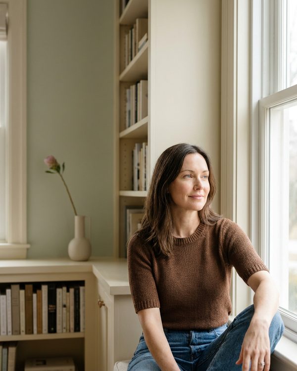 Woman by window, focused and clear-headed
